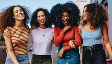 Vrouw met gezonde, pluisvrije krullen na een complete krullen routine volgens de Curly Girl methode.